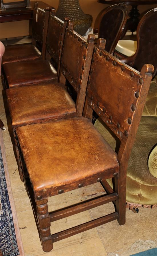 Set of four carved oak chairs, upholstered in studded hide on turned & block supports and stretchers